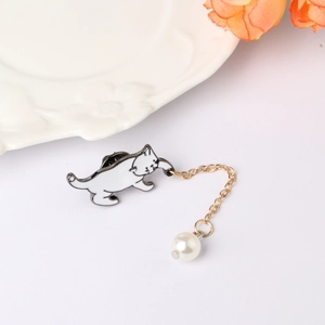 Enamel white cat brooch with golden chain and pearl pendant on a minimalist background