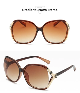 Detail of oversized retro sunglasses with brown gradient lenses and gold flower accents