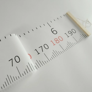 Close-up of Nordic canvas growth chart with clear scale marks and wood hanging frame