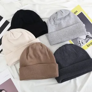 Detail of five assorted colors knitted beanies with wide fold-over cuffs and fine texture
