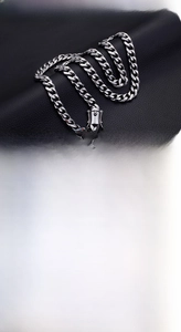 Detailed close-up of heavy-duty silver stainless steel Cuban link chain with secure clasp