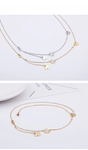 Detail of clover, heart, and infinity necklaces in gold and silver finish on white card