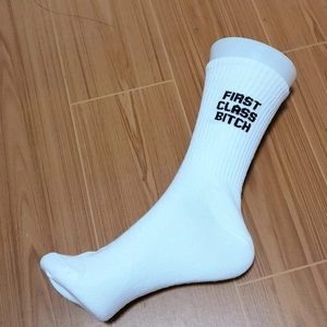 White cotton crew socks featuring black First Class Bitch text on ribbed cuffs