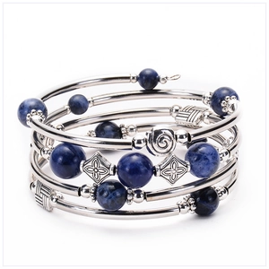 Detail of multi-layer wrap bracelet featuring deep blue beads and silver metal tubes