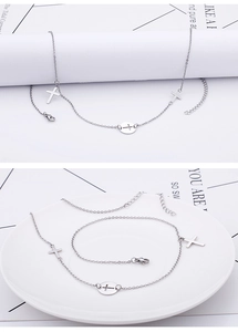 Detail of silver titanium cross necklace featuring three cross pendants on fine link chain
