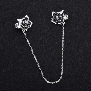 Dettaglio di clip per spilla a rosa nera vintage collegate da catena in metallo