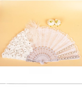 Detail of white lace folding fan with faux pearls and fabric roses decoration