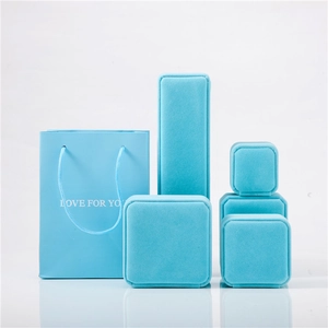 Set of light blue velvet jewelry boxes and matching gift bags in a matrix layout