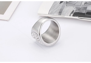 Close-up of wide silver ring with heart-shaped pavé zirconias on minimalist background