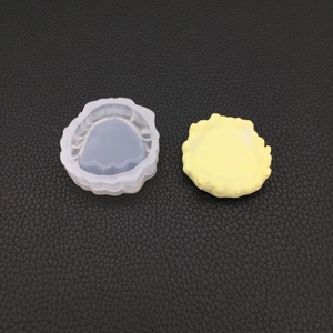 Makroansicht der Silikonform und des gelben Harzstücks auf schwarzem Hintergrund