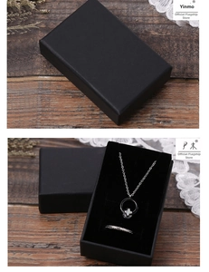 Détail d'un coffret cadeau noir mat avec collier trèfle et bague tressée à l'intérieur