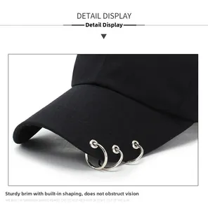 Detail of black baseball cap brim with three silver metal rings and internal shaping layer
