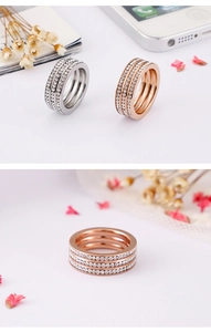 Detailed macro view showing triple-row pave set zircon rings in rose gold and silver finish