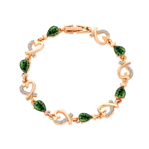 Close-up of rose gold heart link bracelet with green teardrop crystal and zircons