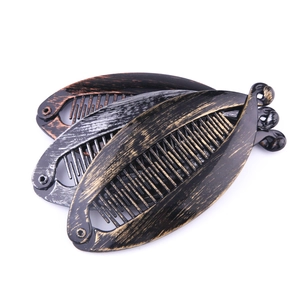 Three matte metallic banana hair clips in bronze, silver, and gold on a white background