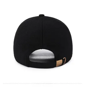 Detailed back view of black wool baseball cap with adjustable bronze metal buckle strap