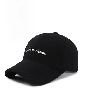Detail of a black winter baseball cap featuring white Freedom cursive embroidery on cotton fabric