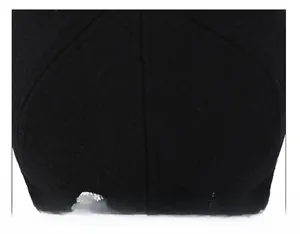 Detail of meticulous top suture technique on black baseball cap with white embroidery