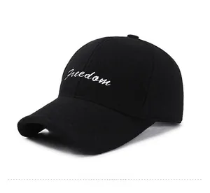 Side view of black wool baseball cap with white Freedom script embroidery on plain background