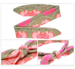 Detail of pink floral headband with knot design showing fabric texture and vibrant pattern