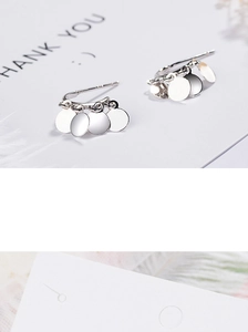 Detail of silver S925 stud earrings featuring minimalist multi-layer circular sequins