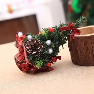 Close-up of 20cm mini Christmas tree with red plaid base, bows, berries and pinecone