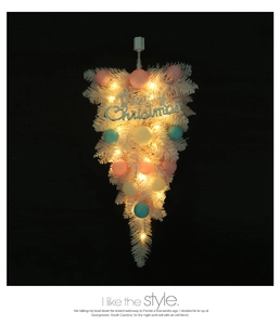 Close-up of pink Christmas upside-down tree with warm LED lights and colorful ball ornaments