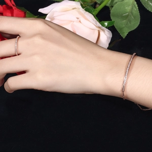 Rose gold jewelry set featuring a zircon paved bracelet and ring on a black velvet background