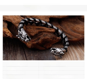 Macro shot of stainless steel dragon head clasp on black braided leather bracelet