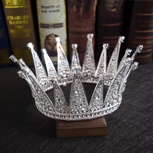 Detailed close-up of a vintage silver bridal tiara with sparkling rhinestones on old books