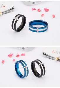 Detail of matte stainless steel rings in black and blue with a center stone inlay