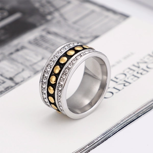 Zilveren brede ring met gouden stippen en zirkoon op tijdschriftachtergrond