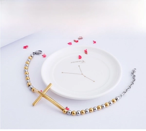 Detailed view of cross beaded bracelet with gold cross and silver steel beads