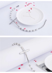 Detail of silver beaded cross bracelet with white pearls and extender chain