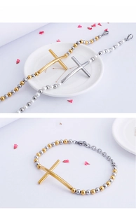 Detailed close-up of gold and silver stainless steel cross bead bracelets on white plate