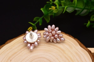 Detailed view of cluster pearl earrings with S925 silver stamp on a wooden texture