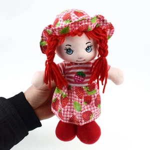 Close-up of cute strawberry plush doll with red hair braids and floral hat details