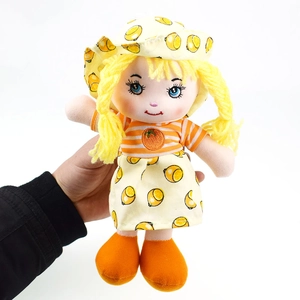 Close-up of plush doll featuring yellow braided hair and lemon print dress outfit