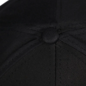 Gros plan du haut de la casquette de baseball noire avec coutures de précision et bouton