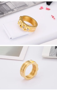 Detailed view of triple-layered gold ring featuring a sparkling central zircon band