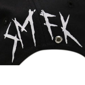 Détail de l'imprimé graffiti AMFK et œillets en métal argenté sur casquette noire