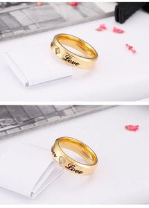 Detail of gold Forever Love couple rings with heart cz stones and black engravings
