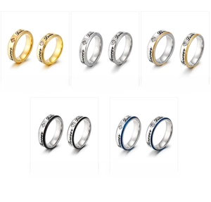 Macro detail of Forever Love engraved stainless steel rings with zircon stones in five colors