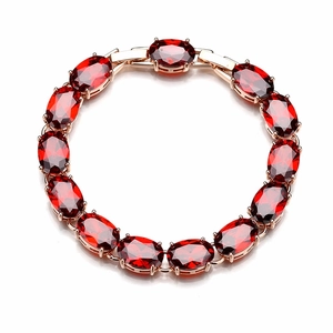 Close-up of luxury ruby red oval-cut crystals set in elegant rose gold bracelet