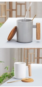 Detail of Nordic ceramic mugs with cylindrical wooden handles, lids, and spoons