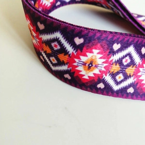 Macro detail of ethnic style woven strap with purple and red geometric diamond patterns