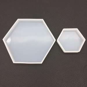 Set of two hexagonal silicone molds for DIY resin crafts on a dark textured surface