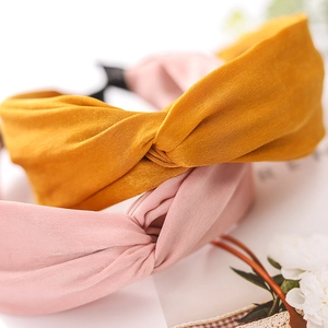 Detail of cross knot design on ginger yellow and pink velvet wide headbands