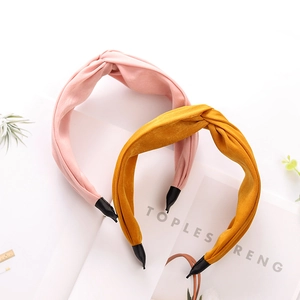 Detail of pink and yellow fabric headbands with elegant knotted design on book background