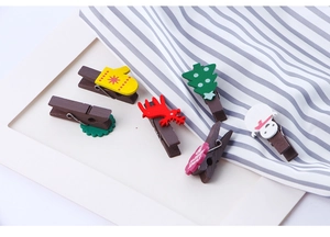 Detail showing various festive Christmas wooden clips like reindeer and snowmen on fabric